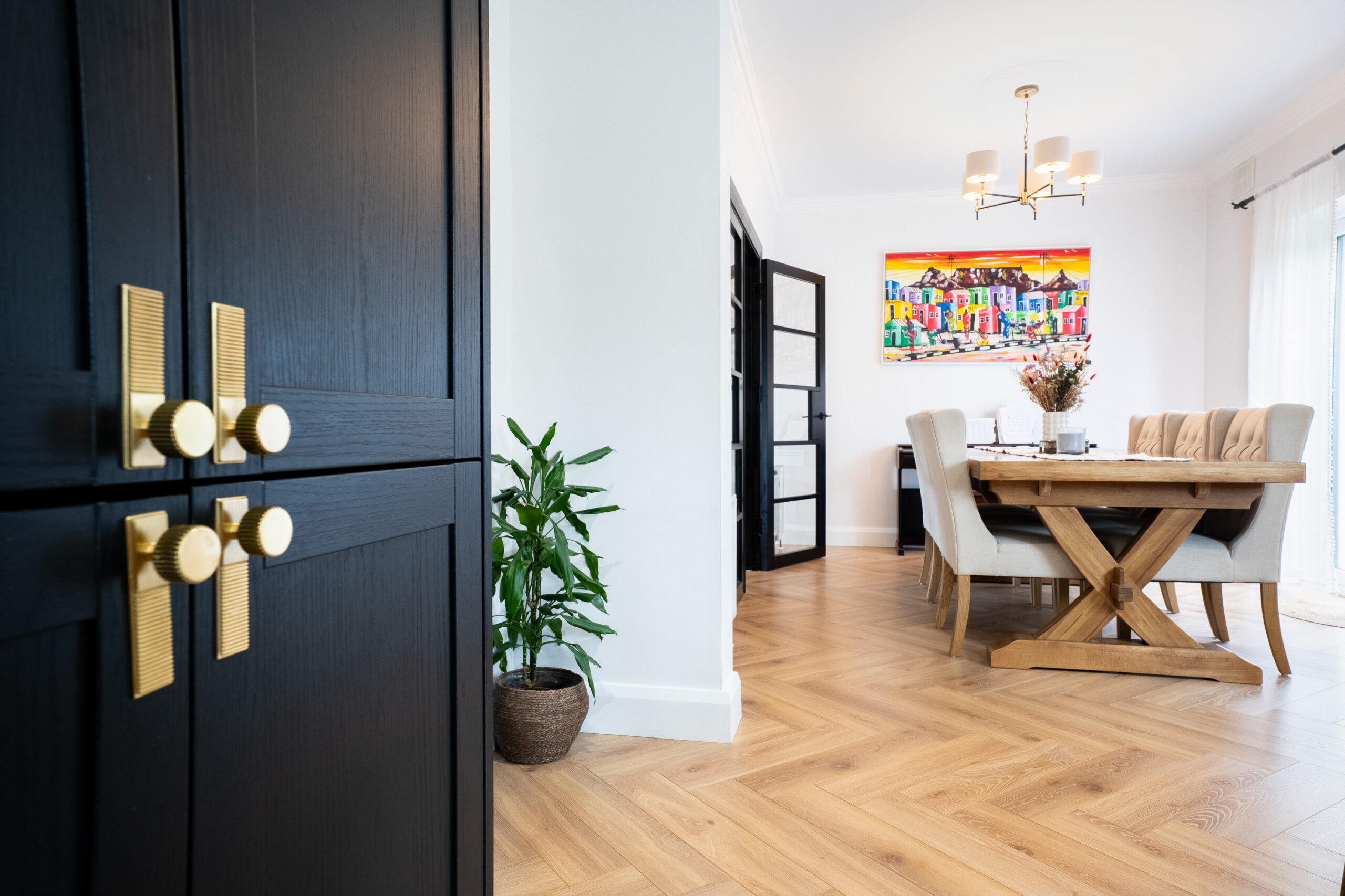 Light herringbone flooring flowing into a dining room