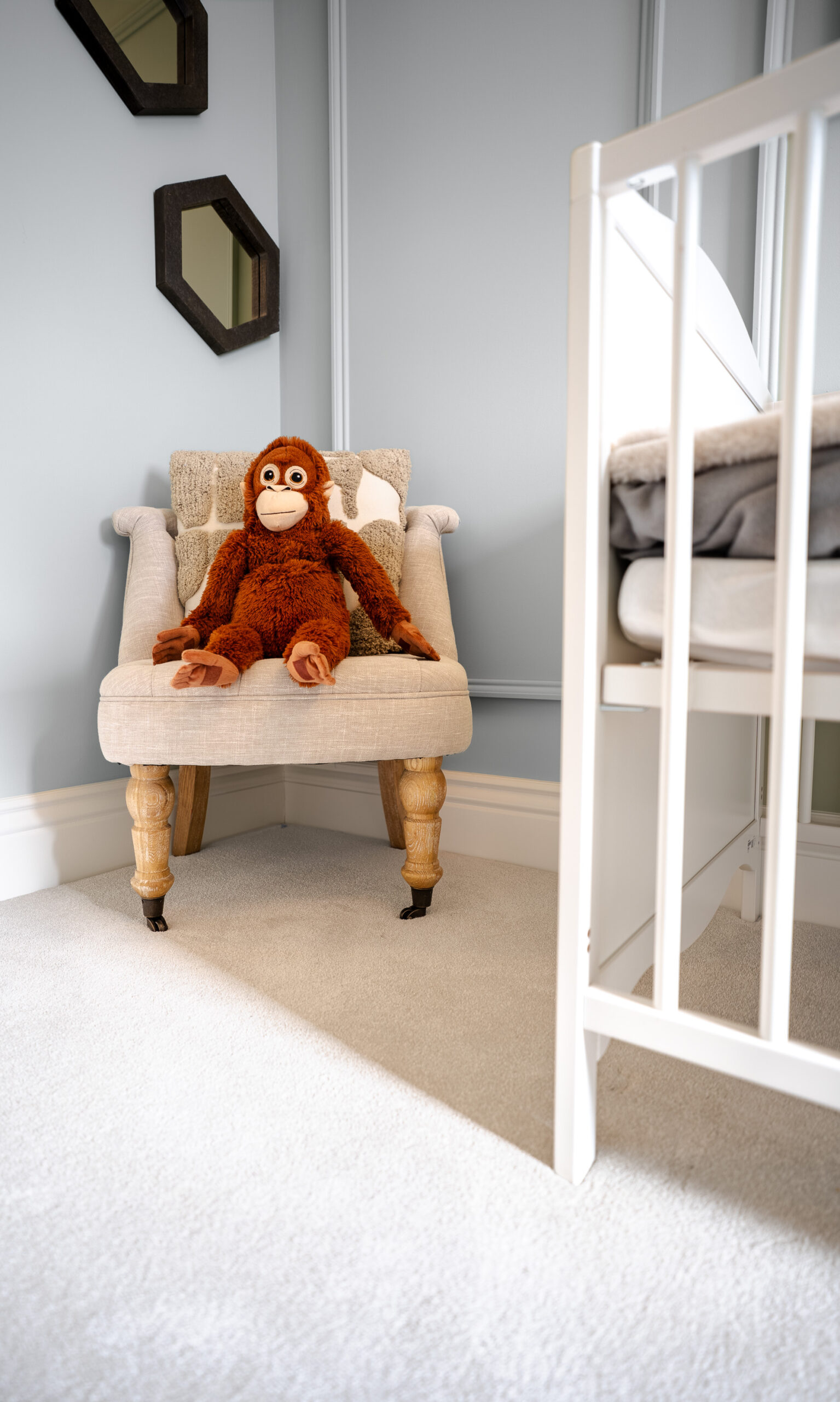 Soft cream bedroom carpet beside an upholstered chair with an orangutan soft toy
