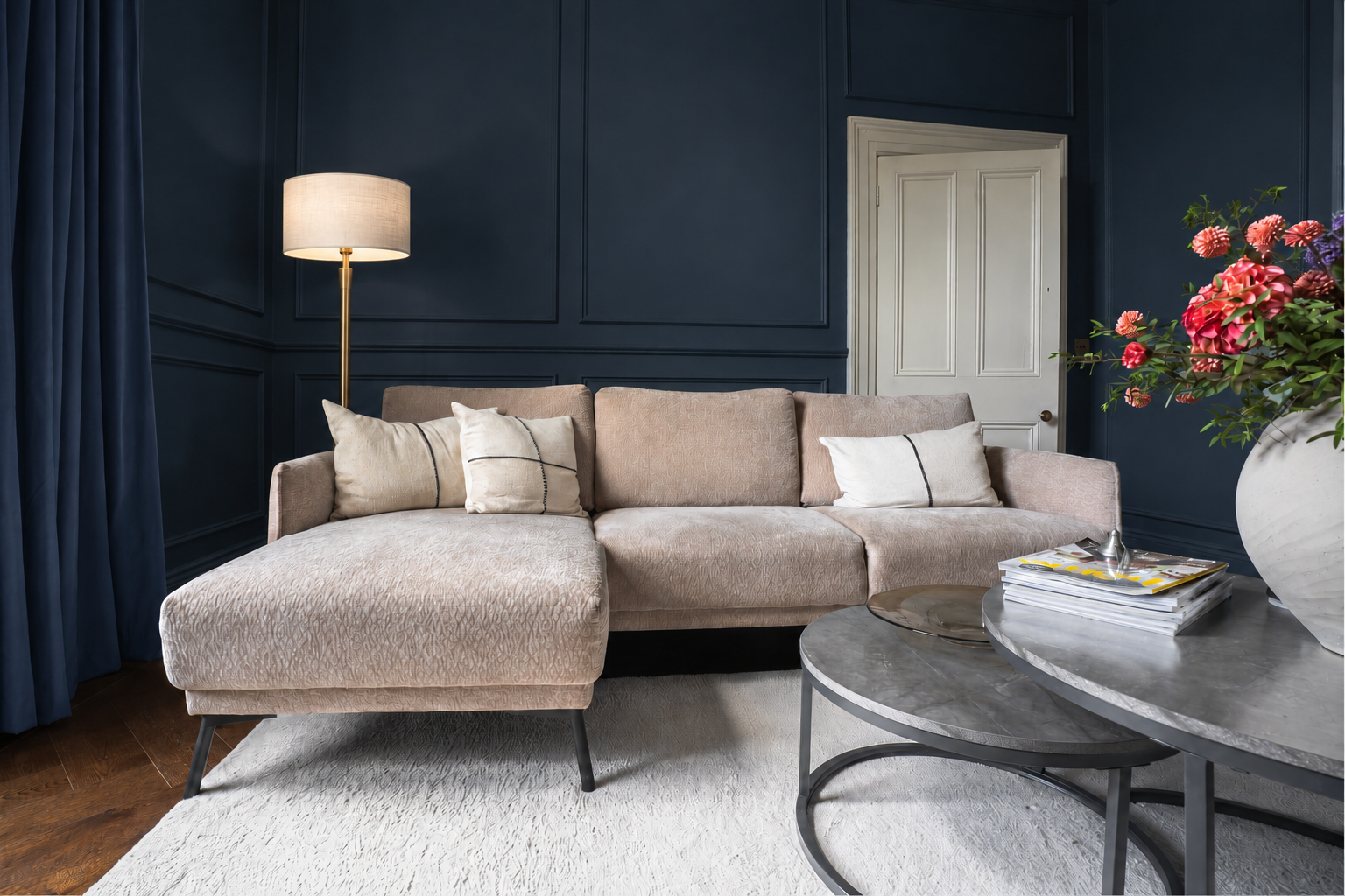 Pale textured rug beneath a neutral sofa in a navy living room